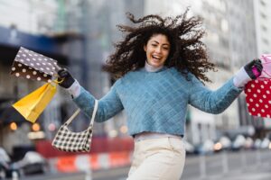 happy woman jumping with shopping bags